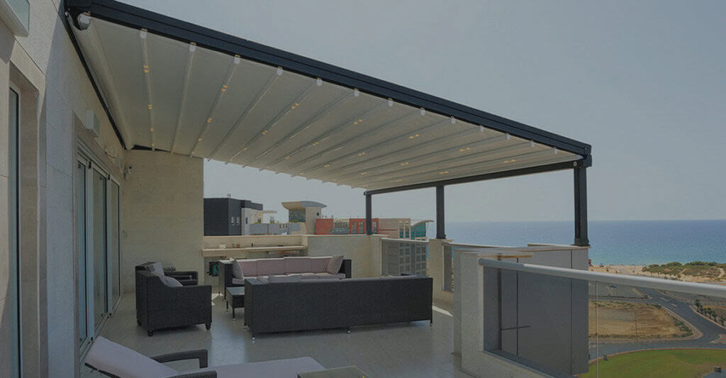 retratable awning Modern patio with ocean view and pergola shade.